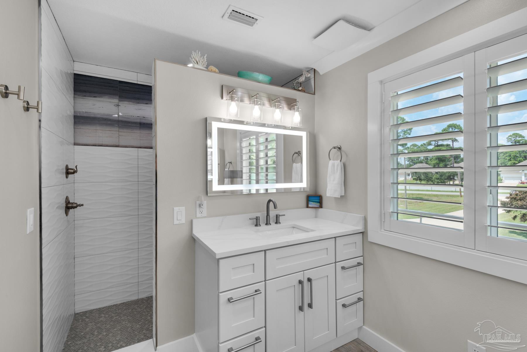 2829 Bay Street Gulf Breeze, FL 32563 - Photo 25 of 69 a bathroom with a sink shower and a mirror