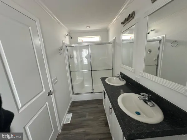 a bathroom with a sink a mirror a toilet and a shower