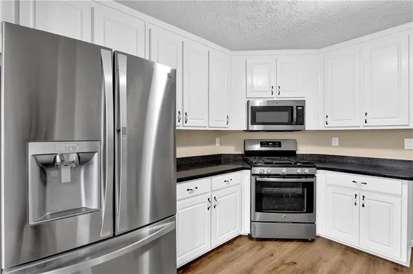 a kitchen with white cabinets and stainless steel appliances
