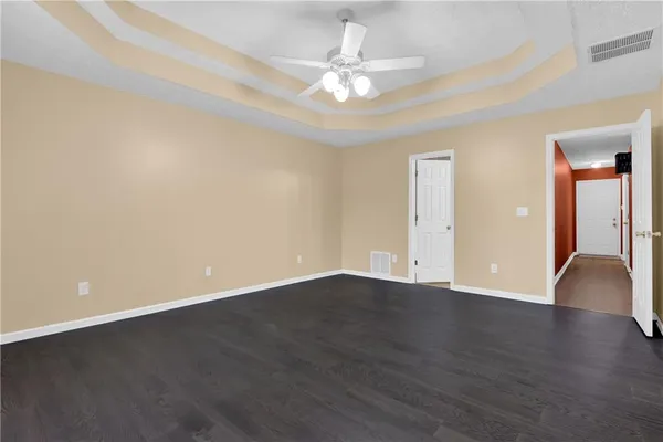 a view of an empty room with window and wooden floor