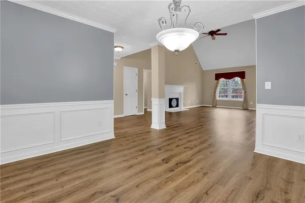 a view of a hallway with wooden floor and chandelier