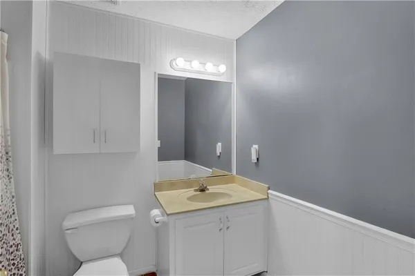 a bathroom with a toilet sink and mirror