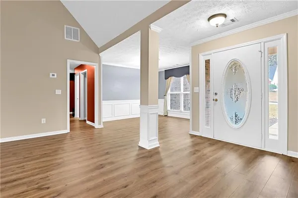 a view of a hallway with wooden floor and front door