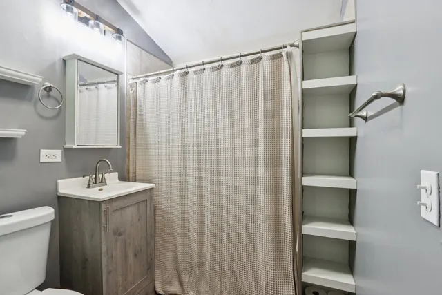 a bathroom with a sink toilet and a mirror