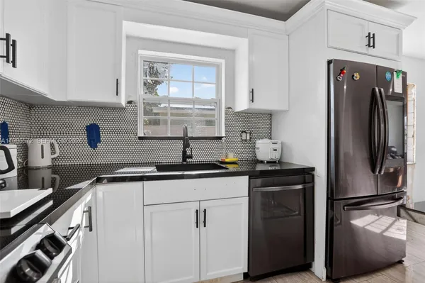 a kitchen with stainless steel appliances granite countertop a refrigerator and a sink