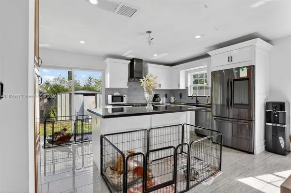 a kitchen with stainless steel appliances granite countertop a refrigerator and a stove top oven