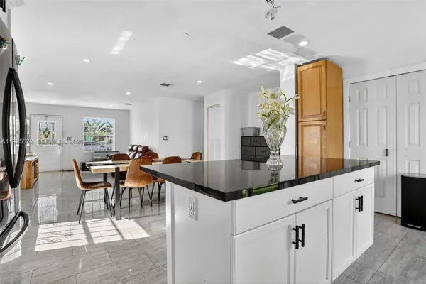 a kitchen with stainless steel appliances kitchen island granite countertop a table and chairs in it