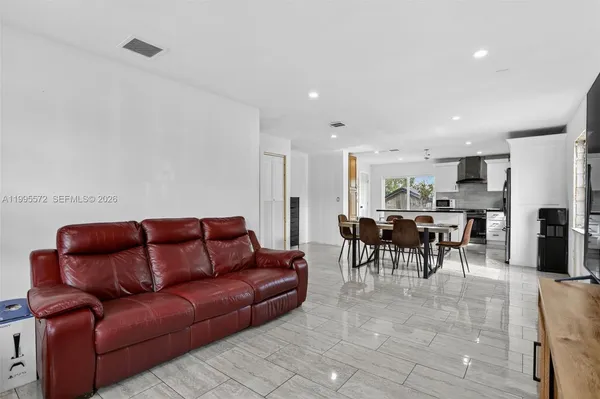a living room with furniture a dining table and kitchen view