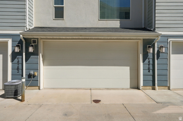 14764 Rising Star Way Riverton, UT 84065 - Photo 31 of 42 Neutral-toned garage door with exterior wall sconces, rain gutters, and siding details