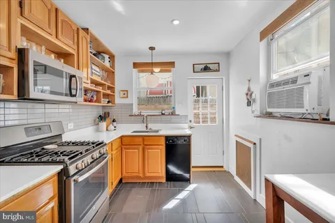 a kitchen with stainless steel appliances granite countertop a stove a sink and a refrigerator