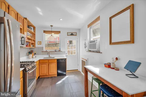 a kitchen with stainless steel appliances granite countertop a refrigerator and a stove top oven