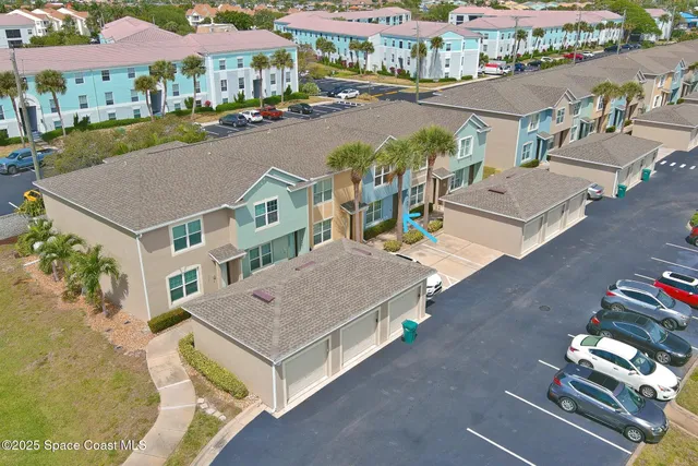 an aerial view of multiple houses with a yard