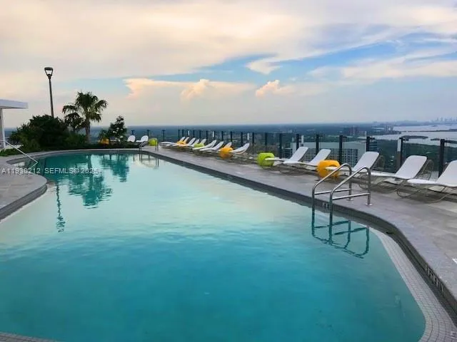 an aerial view of a house with swimming pool and lake view