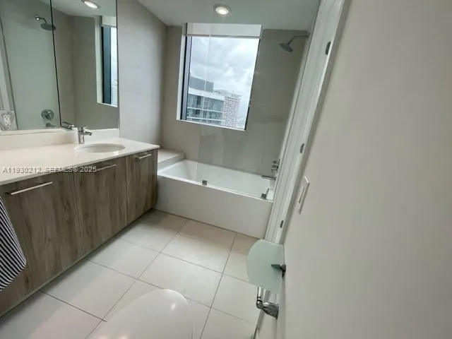 a bathroom with a tub sink and mirror