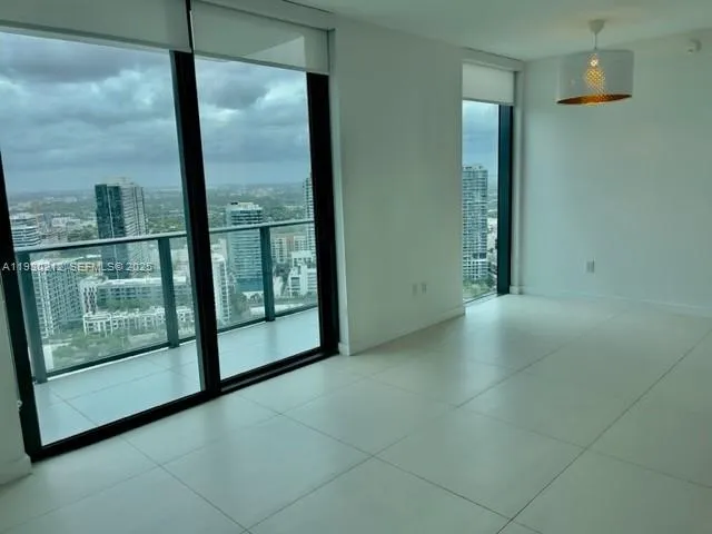 a view of a kitchen with refrigerator and white cabinets