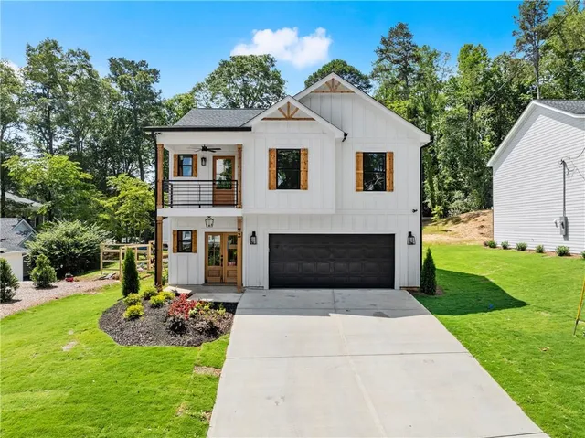 a front view of a house with a garden and yard