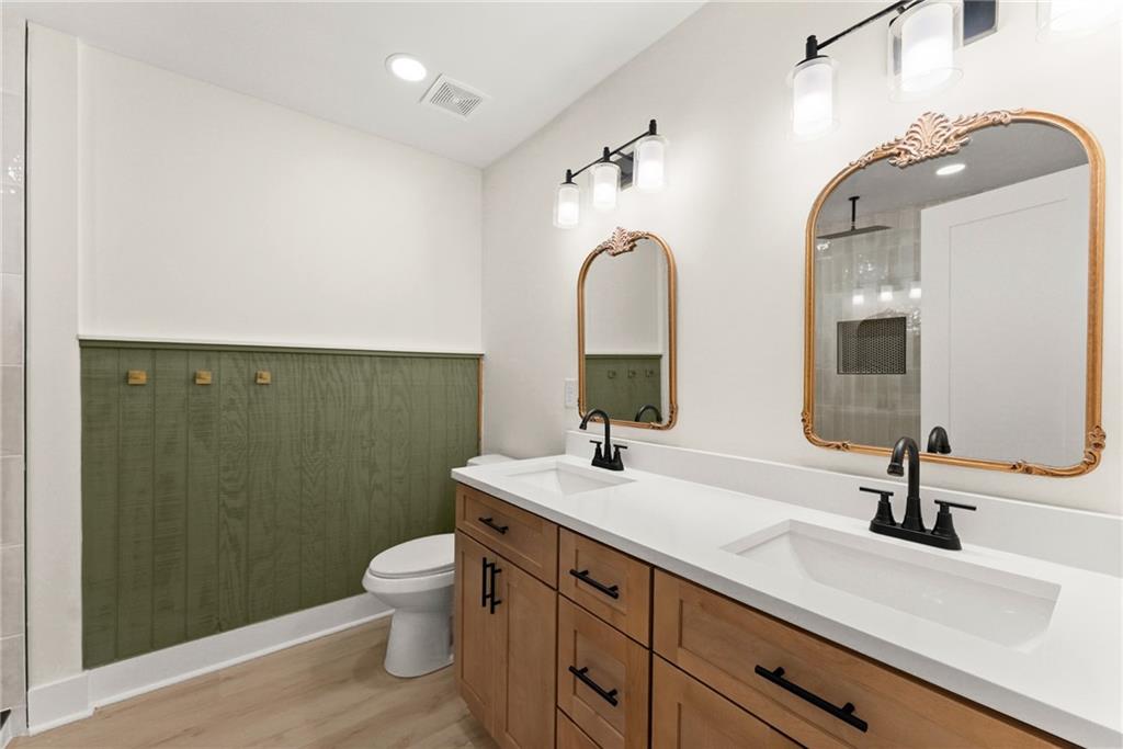 172 Llewellyn Street Clarkesville, GA 30523 - Photo 22 of 44 a bathroom with a double vanity sink toilet and a mirror
