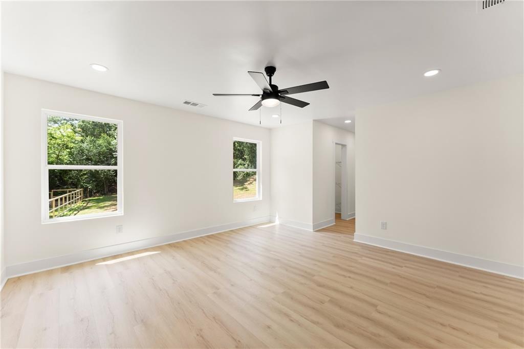 172 Llewellyn Street Clarkesville, GA 30523 - Photo 23 of 49 an empty room with wooden floor chandelier fan and windows