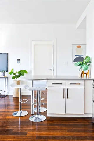 a kitchen with a refrigerator a stove and wooden floor