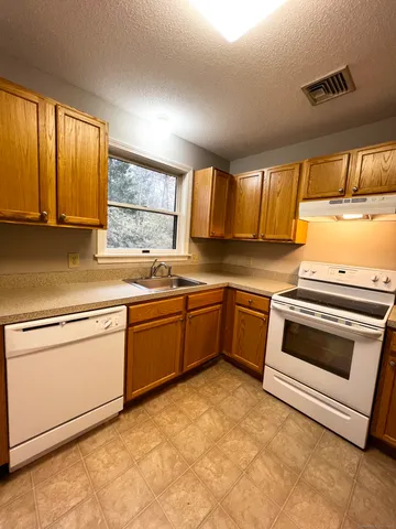 a kitchen with a stove sink and window