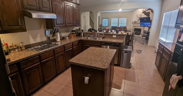 a kitchen with stainless steel appliances granite countertop a stove a sink dishwasher and cabinets