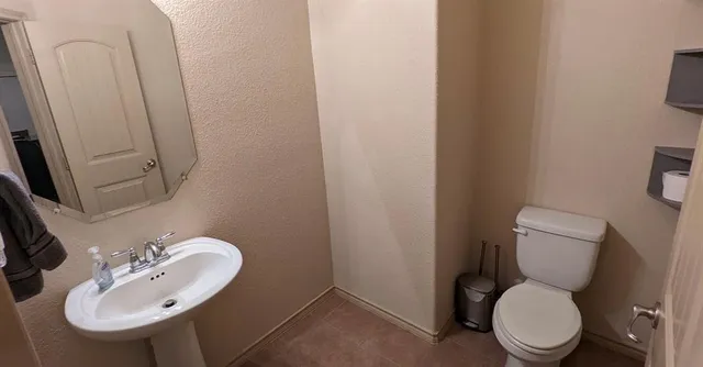 a white toilet sitting next to a bathroom sink