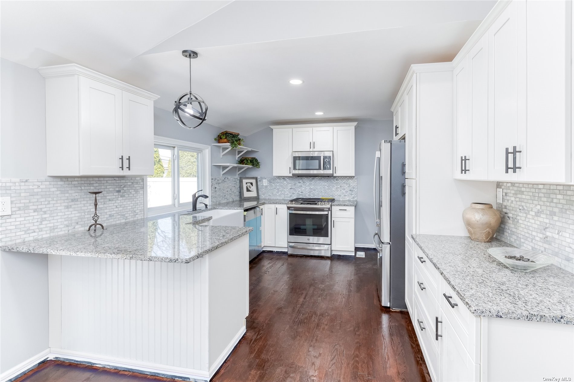 a large kitchen with granite countertop a sink dishwasher stove and oven with wooden floor