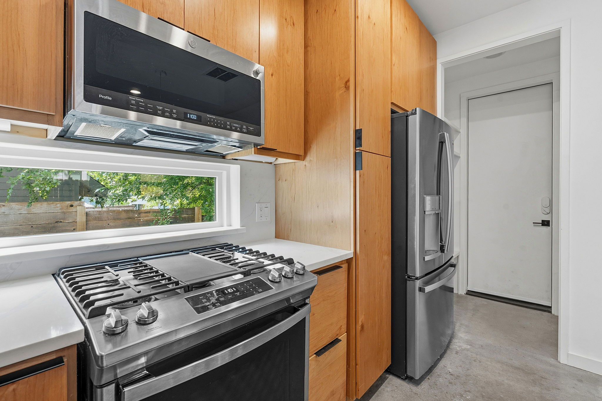 1707 Deloney Street, Unit 2 Austin, TX 78721 - Photo 11 of 26 A streamlined kitchen layout with wood cabinetry and stainless steel appliances, perfect for urban living.