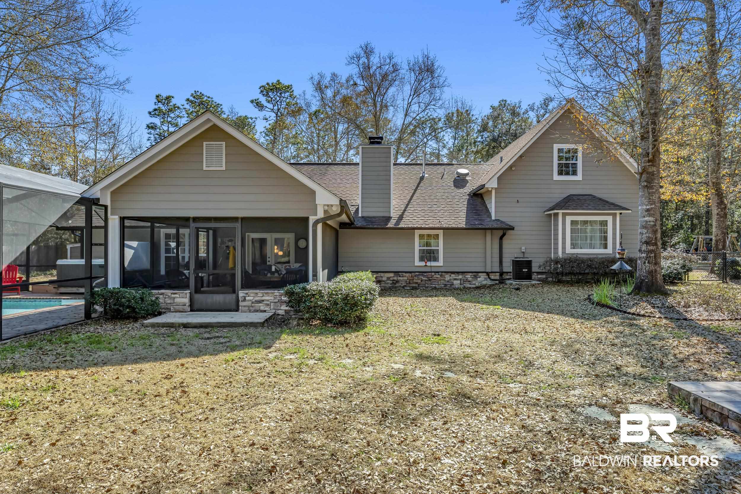 22929 Highway 98 Foley, AL 36535 - Photo 44 of 54 Rear view of house featuring a sunroom, a chimney, a shingled roof, an outdoor pool, and glass enclosure