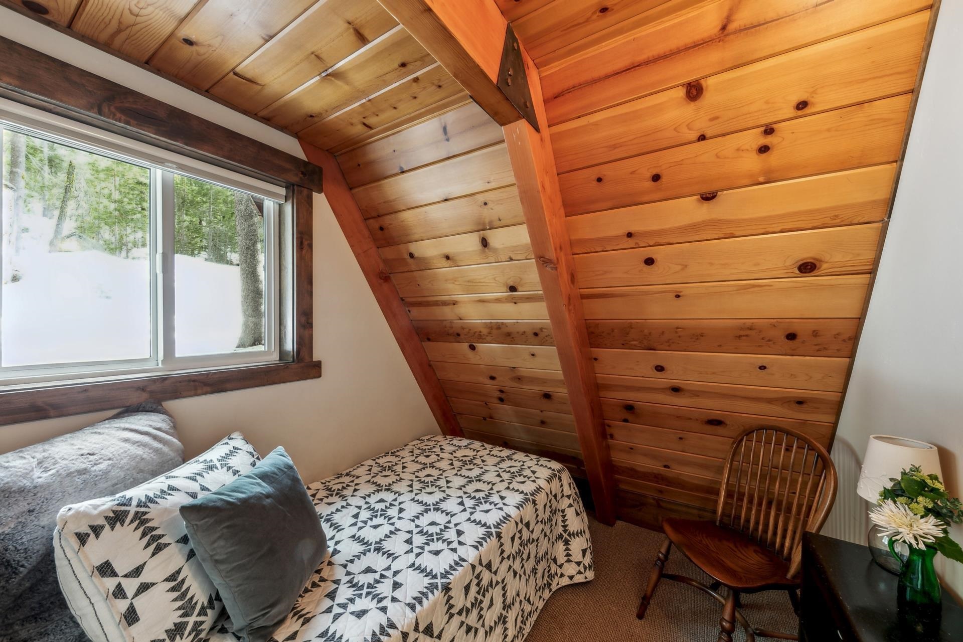 15501 Conifer Drive Truckee, CA 96161 - Photo 11 of 28 a bedroom with a bed and a chair