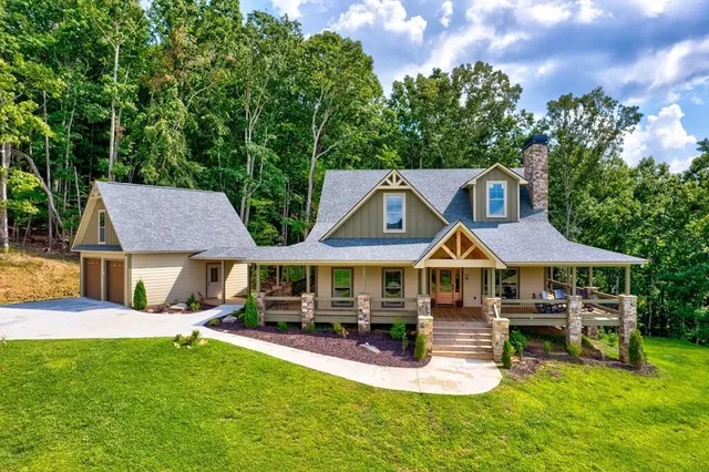 a view of a white house with a big yard and large trees