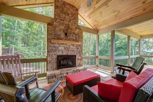 a living room with furniture a fireplace and a floor to ceiling window