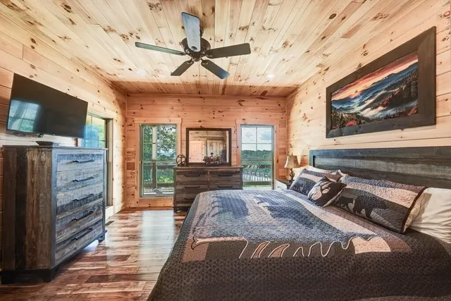 a spacious bedroom with a bed a flat screen tv and a dresser
