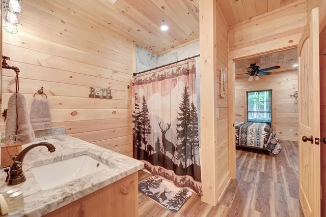 a bathroom with a granite countertop sink a mirror and shower
