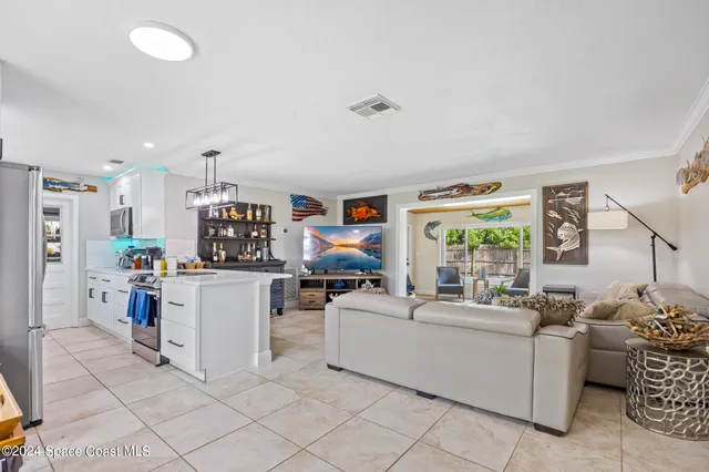 a living room with furniture and a kitchen area