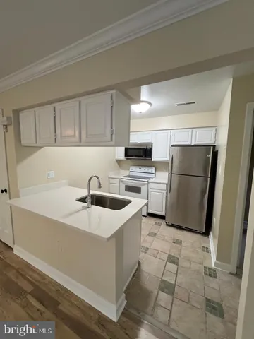 a kitchen with a sink a refrigerator and cabinets