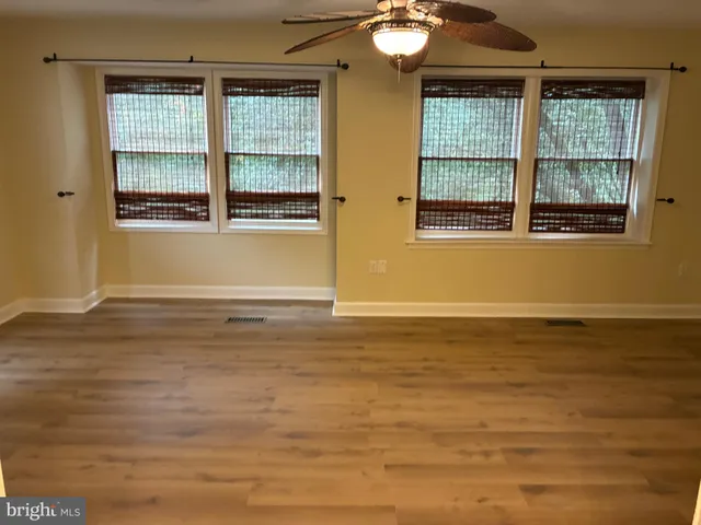 a view of a room with wooden floor and windows