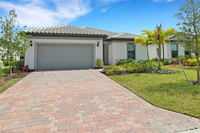 a front view of a house with a garden and yard
