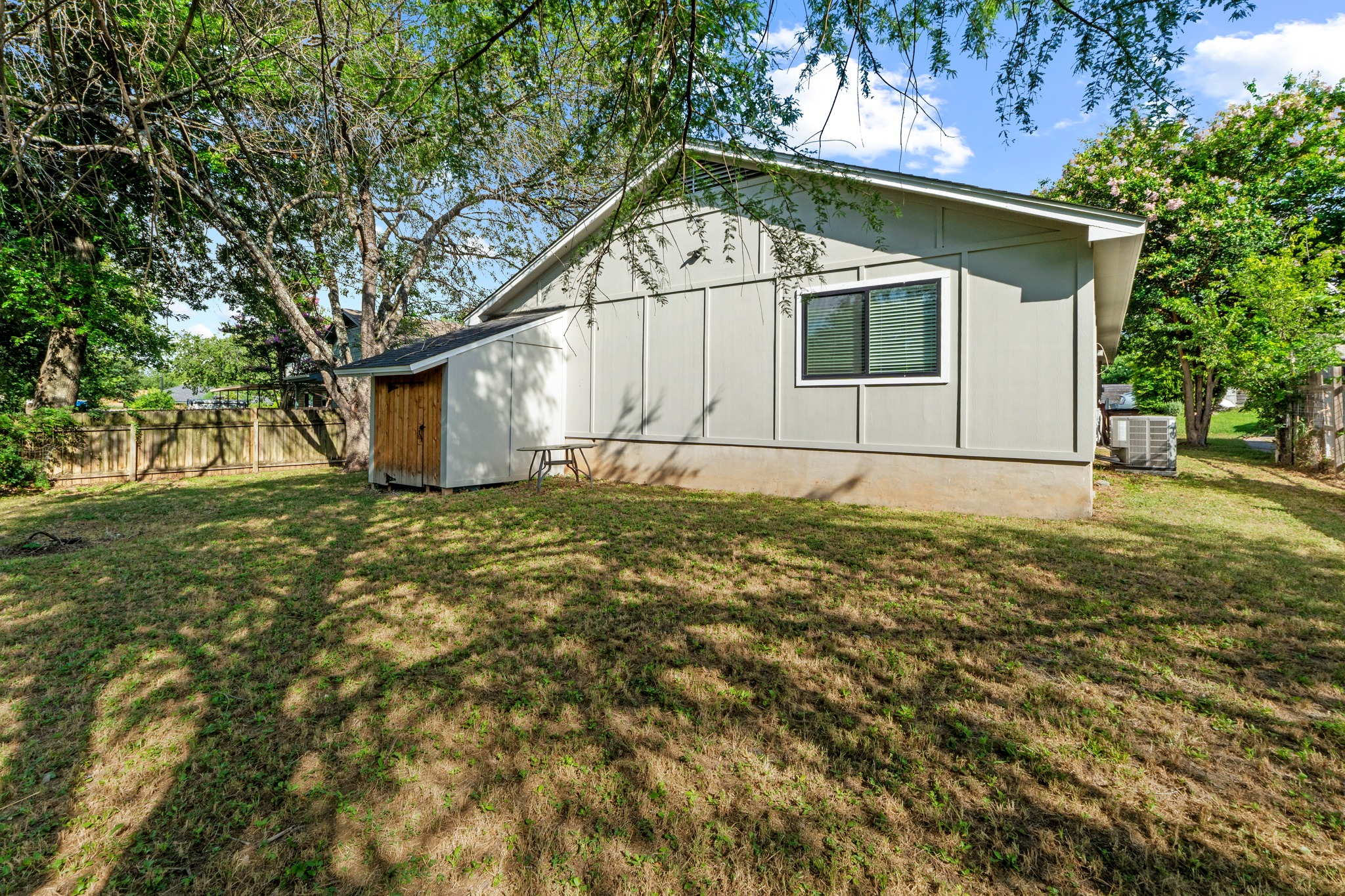 11811 Rotherham Drive Austin, TX 78754 - Photo 33 of 37 A well-maintained side yard featuring a private shed and mature shade trees.