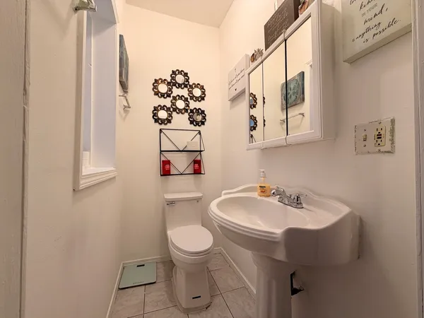 a bathroom with a sink and mirror with toilet