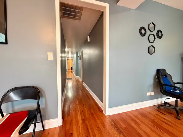 a view of a hallway to a room with wooden floor windows and entryway