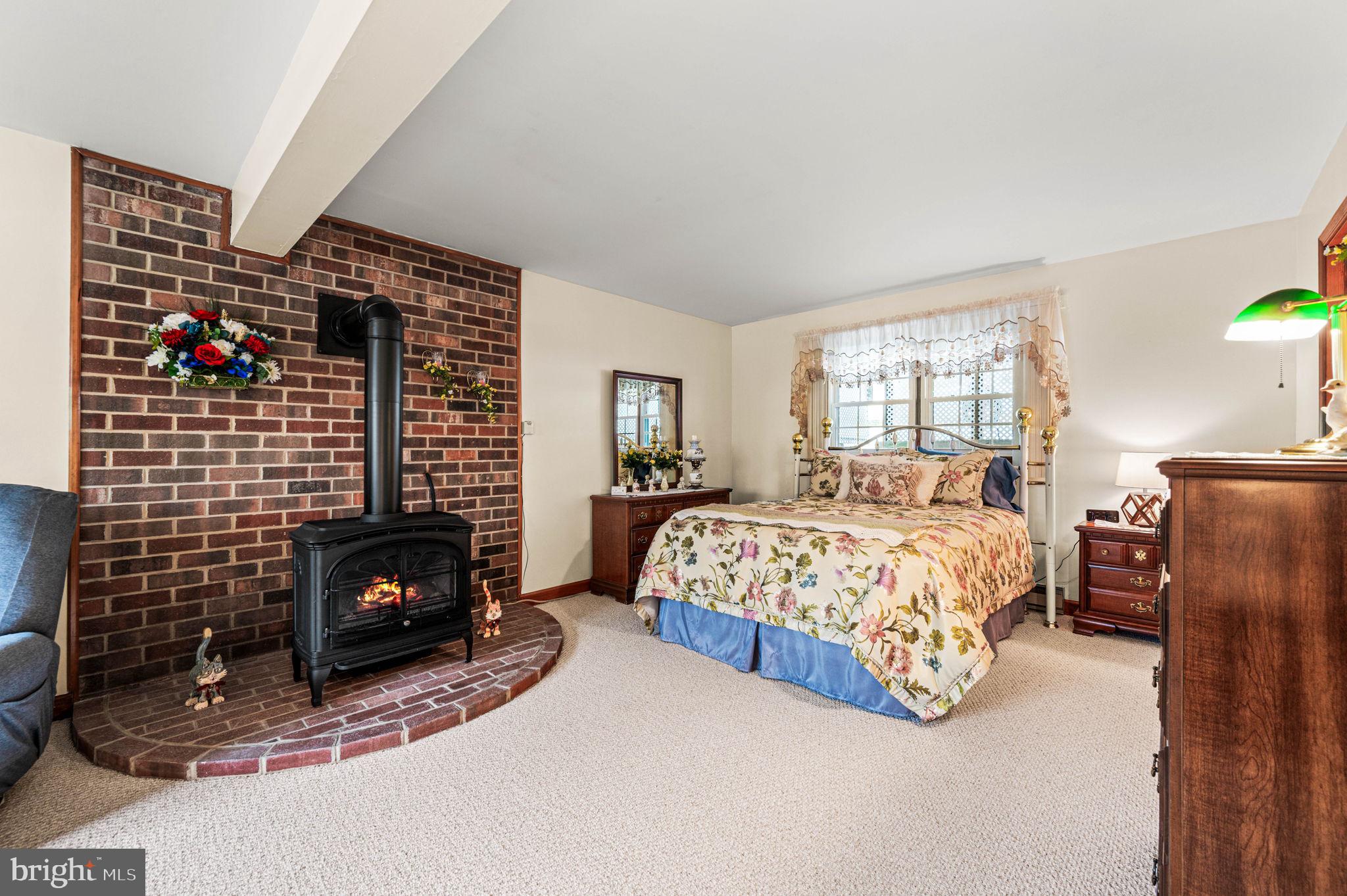 1548 County Line Road Bechtelsville, PA 19505 - Photo 18 of 31 a bedroom with a bed chair and a fireplace