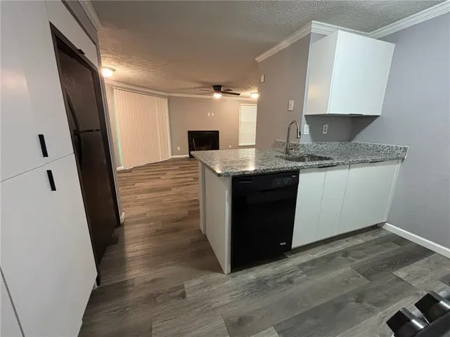 a view of kitchen with granite countertop sink stove refrigerator and cabinets