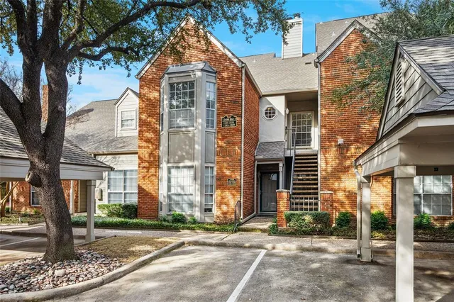 front view of a brick house with a yard
