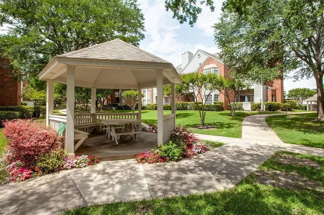 a view of a chair and table in backyard of the house