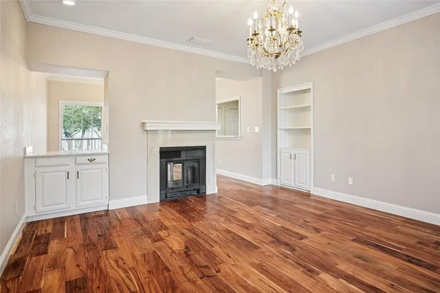 a view of empty room with wooden floor and fireplace