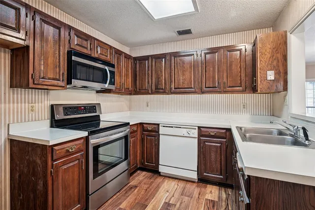 a kitchen with stainless steel appliances a stove sink microwave and cabinets