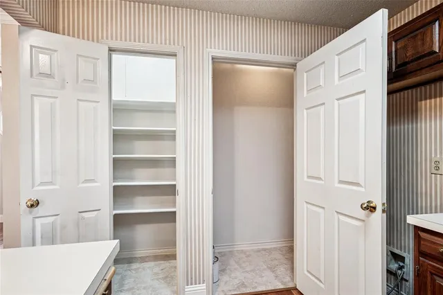 a view of walk in closet with empty racks