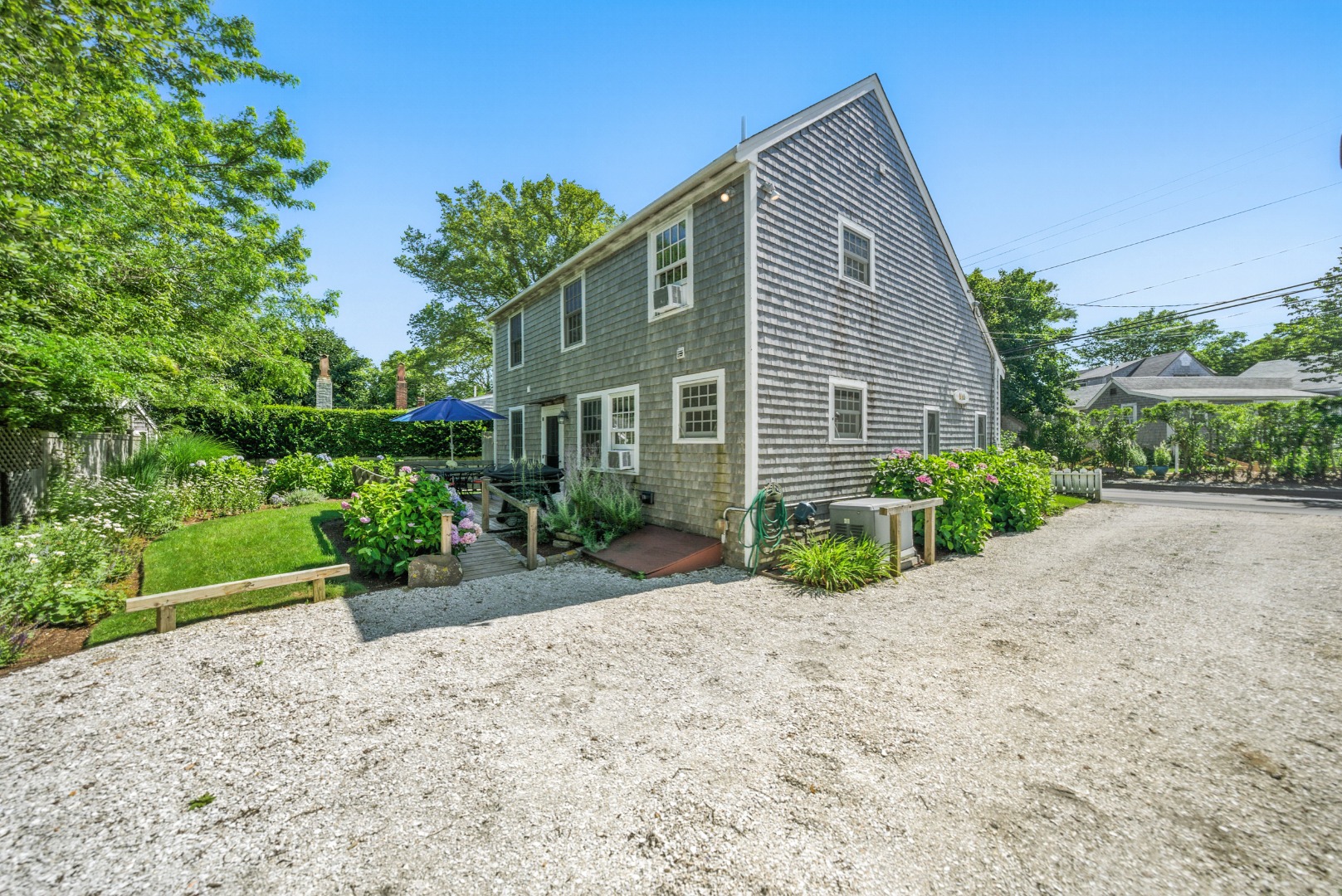 52 Pleasant Street Nantucket, MA 02554 - Photo 31 of 36 a front view of a house with a yard and potted plants