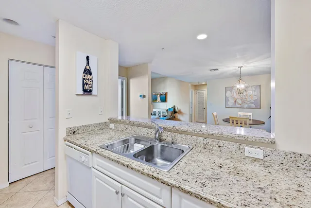 a kitchen with granite countertop a sink a counter top space and cabinets
